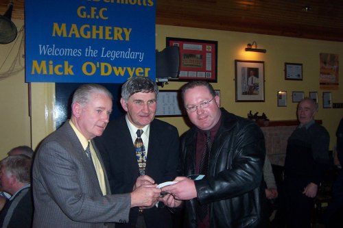 Owen McCrohan (left) and Mick O'Dwyer (centre) sign a copy of 
