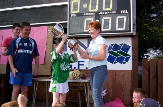 Bernie Cusack presents the Larry Bo Cusack Memorial Cup to the captain of the victorious Wolfe Tones team